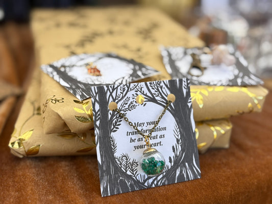 Necklace with a card on a table with wrapped gifts
