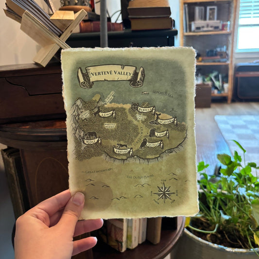 Hand holding a map of Verteve Valley against a blurred indoor background